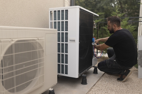 electrician installing a heat pump in the yard